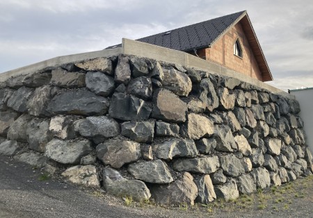 Hang aus Steinbloecken vor Einfamilienhaus